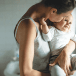 mom holding newborn in bathroom