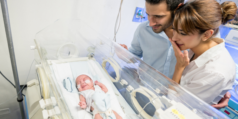 Mother and father looking at their NICU baby