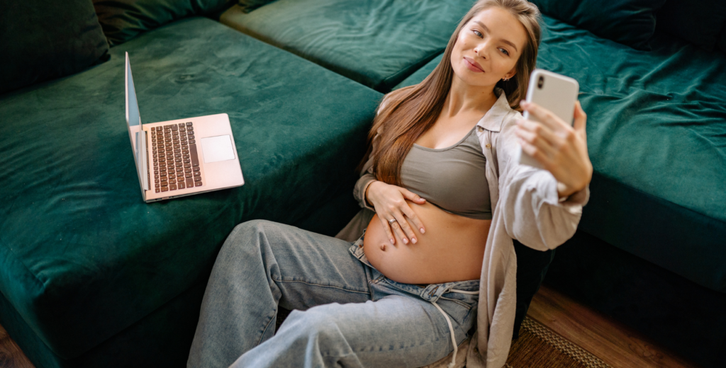 pregnant mom browsing baby names on phone and laptop researching pop culture